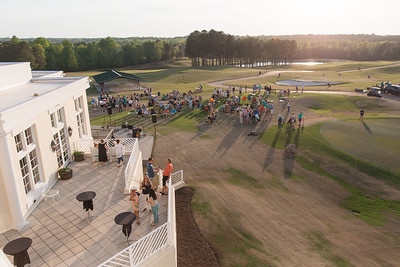 Guests gathered on the Independence Golf Club veranda at sunset, with the course beyond.